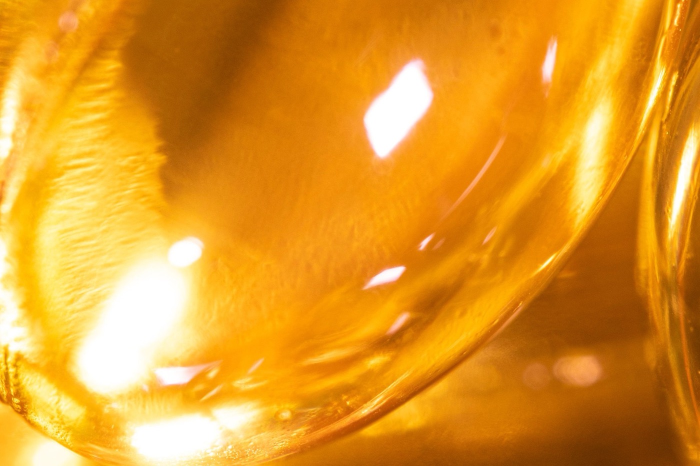 Close-up of translucent gold softgel capsules